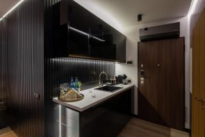 a kitchen with a sink and a counter top at Wiślane Tarasy VIP Apartamenty JACUZZI in Krakow
