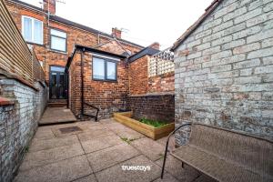 una casa in mattoni con panchina in un cortile di Campbell House by Truestays - NEW 2 Bedroom House in Stoke-on-Trent a Trent Vale