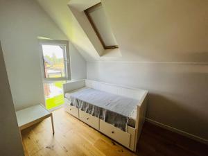 a small bedroom with a bed and a window at Dom wakacyjny NORDA in Dębki