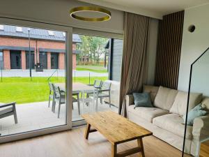 a living room with a couch and a table at Dom wakacyjny NORDA in Dębki