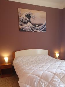 a bedroom with a white bed and a painting on the wall at APPARTAMENTO TRILOCALE CON TERRAZZO ZONA CENTRALE in Grottammare