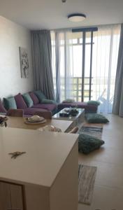 una sala de estar con sofás morados en الجاده, en Sharjah