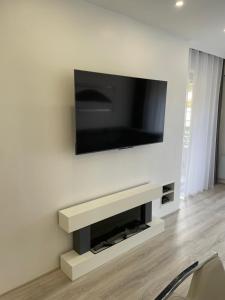 a living room with a television on a wall at Appartement neuf près de la mer in Nice