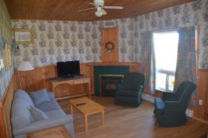 sala de estar con sofá, sillas y TV en Sundance Cottages, en Cavendish