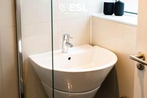 a bathroom with a sink and a glass wall at 2 Bedroom Terrace Cottage, Parking, 5 minutes drive to Royal Shrewsbury Hospital in Shrewsbury +27 photos