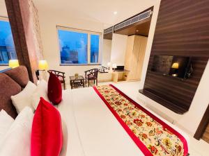 um quarto com uma grande cama branca com almofadas vermelhas em Hotel The Savode - Just 2 Mins From Golden Temple Amritsar em Amritsar