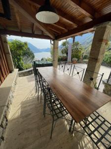 Une table et des chaises en bois sont disponibles sur la terrasse. dans l'établissement Historic villa with magnificent lake views, à Valsolda