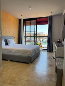 um quarto com uma cama grande e uma janela grande em Delice Mavi em Ildır