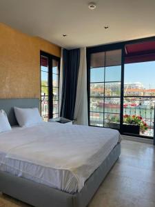 een slaapkamer met een groot bed en grote ramen bij Delice Mavi in Ildır