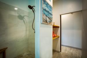 a shower with a glass door in a bathroom at The Sea Glass Inn in Placencia