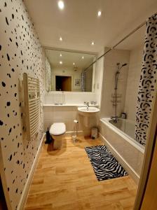 e bagno con servizi igienici, lavandino e vasca. di Beautiful Marina Apartment with private garden, flexible bedrooms with zip & link beds a Gosport