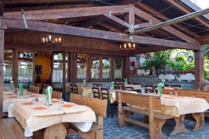 um restaurante com mesas e bancos de madeira em Locanda Romana em Fanano