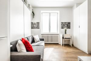 ein Wohnzimmer mit einem Sofa und einem Fenster in der Unterkunft City Life House-RED Free Parking San Siro & Duomo in Mailand