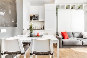 a kitchen and living room with a white table and chairs at [City Life House-RED] San Siro & Duomo in Milan