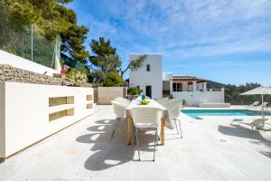 eine Terrasse mit Tisch und Stühlen neben einem Pool in der Unterkunft Villa Casiopea in Ibiza-Stadt