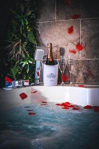 una bottiglia di champagne e 2 bicchieri su una vasca da bagno di Suite évasion au cœur des vignes a Sorgues