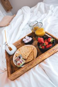 un vassoio di cibo con pane e frutta su un letto di Suite évasion au cœur des vignes a Sorgues