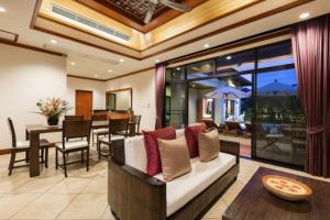 Residence Lake Rawai في فوكيت تاون: غرفة معيشة مع أريكة وغرفة طعام