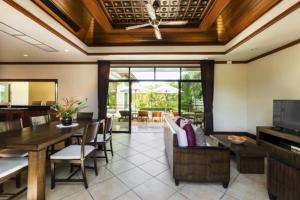 ein Wohnzimmer mit einem Sofa und einem Esszimmer in der Unterkunft Residence Lake Rawai in Phuket