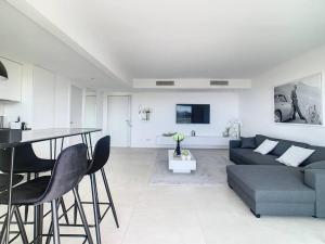 ein Wohnzimmer mit einem Sofa, einem Tisch und Stühlen in der Unterkunft Magnifique appartement vue mer in Vallauris
