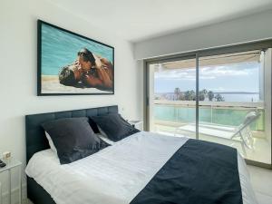 ein Schlafzimmer mit einem Bett und einem großen Fenster in der Unterkunft Magnifique appartement vue mer in Vallauris