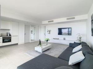 ein Wohnzimmer mit einem Sofa und einer Küche in der Unterkunft Magnifique appartement vue mer in Vallauris