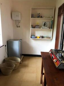 a kitchen with a refrigerator in the corner of a room at Hondo Hondo House in Mto wa Mbu