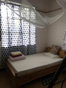 a bed with a canopy in a room with a window at Hondo Hondo House in Mto wa Mbu