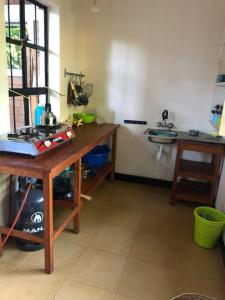 a kitchen with a wooden table and a sink at Hondo Hondo House in Mto wa Mbu +15 photos