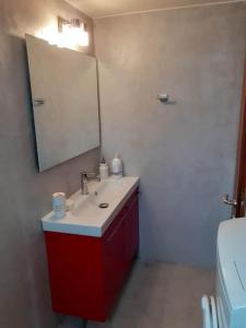 a bathroom with a red sink and a mirror at Cottage house with incredible view in Trápeza