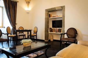 uma sala de estar com uma mesa e cadeiras e uma televiso em Convento Da Serta Hotel na Sert
