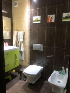 a bathroom with a white toilet and a sink at Family View Sunset Apartment in Varna City