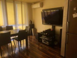 a dining room with a table and a television at Family View Sunset Apartment in Varna City