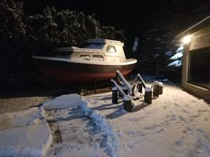a boat is parked in the snow at night at 100SaulesVikingi in Grobiņa