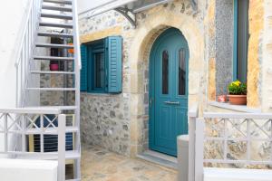 una puerta azul en una casa de piedra con una escalera en Konstantis en Kroústas
