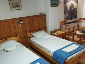 Guesthouse Chryssoula في مدينة خانيا: غرفة نوم بسريرين وطاولة وكراسي