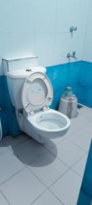 a bathroom with a white toilet in a blue room at CENTRAL GATE in Chennai