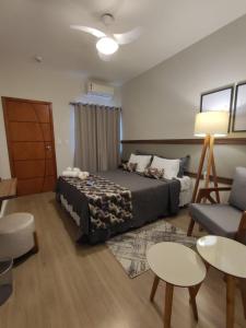 um quarto com uma cama, um sofá e uma mesa em Hotel Capital da Fe em Aparecida