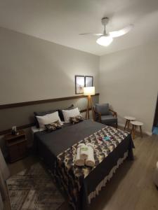 um quarto com uma cama grande e uma cadeira em Hotel Capital da Fe em Aparecida