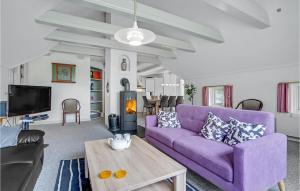 un soggiorno con divano viola e tavolo di Stunning Home In Blvand With Kitchen a Blåvand