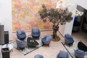 a waiting room with chairs and a tree mural at Thalazur Antibes - Hôtel & Spa in Antibes