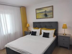 a bedroom with a large white bed with two lamps at Apartament Faleza Nord in Constanţa