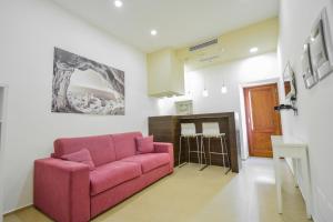 a living room with a pink couch in a room at La Rosa dei Venti in Cefalù