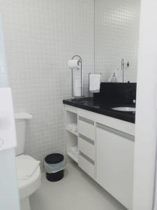 uma casa de banho branca com um lavatório e um WC em AP Decorado no Circuito do Carnaval de Salvador em Salvador