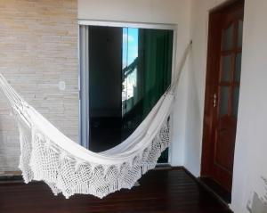 a hammock hanging in a room with a window at Quarto com Varanda - Recanto do Sabiá in Campinas