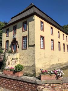 a building with two flower pots in front of it at Charmante Ferienwohnungen auf Reitstall Wasserburg Anstel - ein Ort zum Wohlfühlen und Entspannen in Rommerskirchen