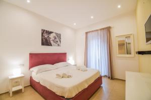 a bedroom with a large bed with two towels on it at La Rosa dei Venti in Cefal&ugrave;