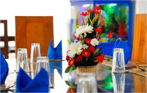 a vase filled with red and white flowers on a table at Ronaka Airport Transit Hotel in Katunayake