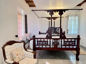 a bedroom with a bed and a chair in a room at The Heyday in Vagamon