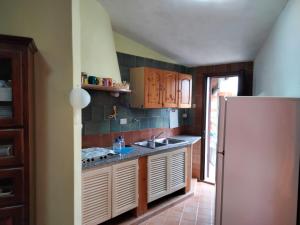 a kitchen with a sink and a refrigerator at limone in Carloforte +6 photos